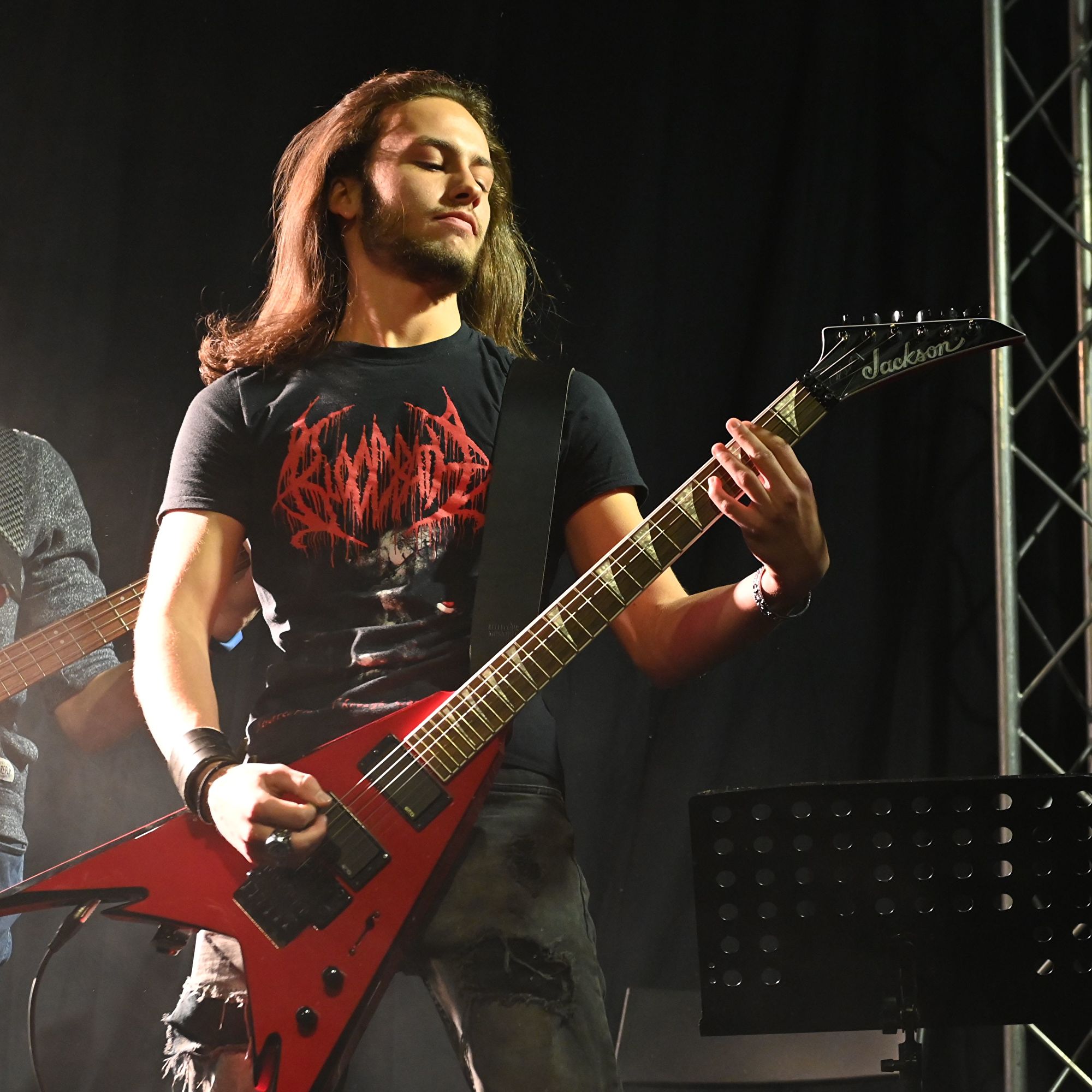 élève jouant de la guitare électrique sur scène lors d'un concert de l'école Muzikadem.